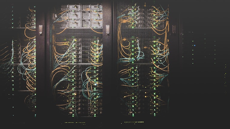 Rows of server racks with blue indicator lights in a data center aisle
