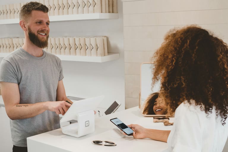 Customer tapping a payment card on a countertop card reader