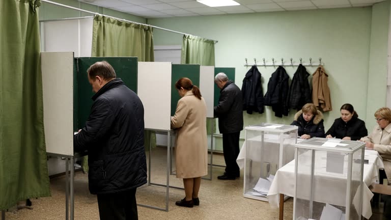 Moscow polling station interior with voters at booths under fluorescent lights, coat hooks and faded green curtains, election officials at a table with sealed ballot boxes, no readable text or logos