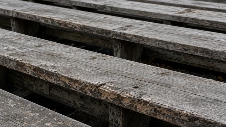 Empty scuffed wooden bleacher plank in overcast daylight, no people, no logos, no readable text