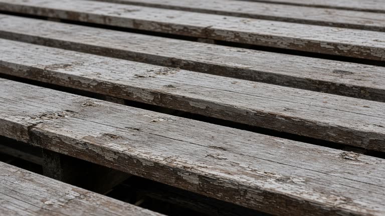Empty scuffed wooden bleacher plank in overcast daylight, no people, no logos, no readable text
