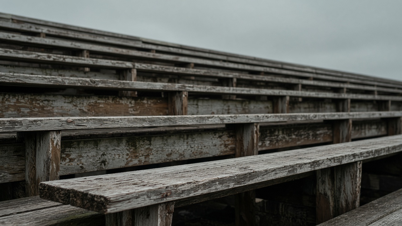 Empty scuffed wooden bleacher plank in overcast daylight, no people, no logos, no readable text