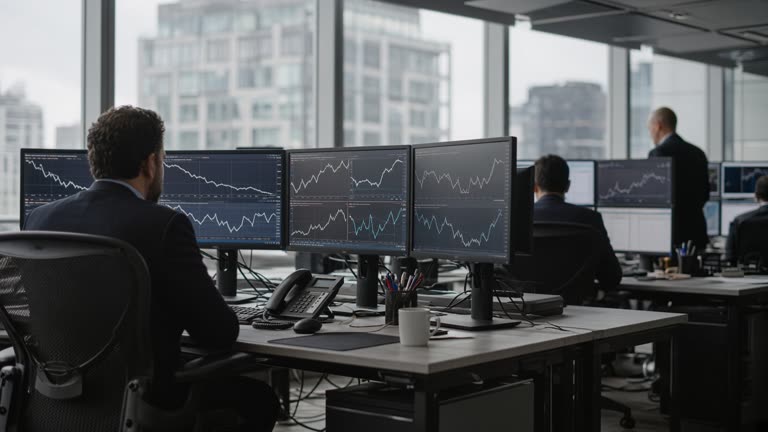 City of London office interior with traders at desks and multiple market monitors showing bond yield curves, grey daylight through windows, no readable text on screens.