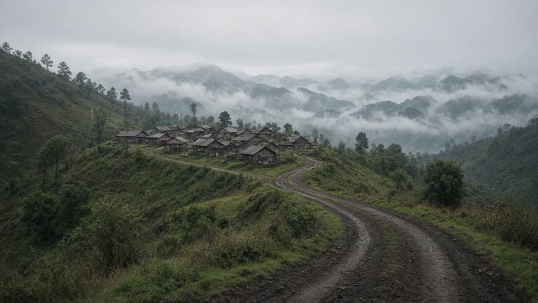 A remote hill village in Manipur's Kamjong district at dawn, with bamboo houses and a narrow dirt path leading toward a mist-covered border ridge, no logos or readable text.