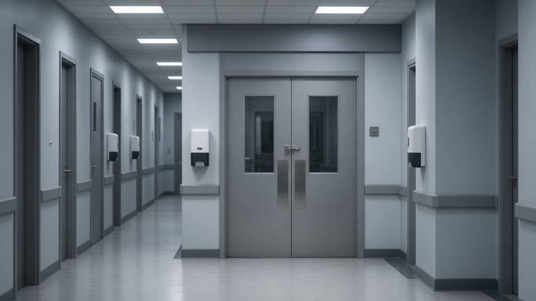 Hospital corridor with closed triage doors and hand sanitiser stations, cool fluorescent lighting, no logos or readable text