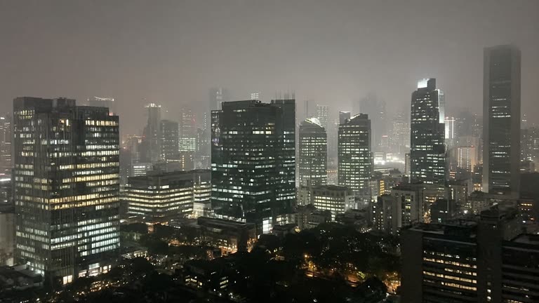 Photoreal scene of Singapore’s downtown skyline at night under a pale grey haze, office lights softened and no logos or readable text.