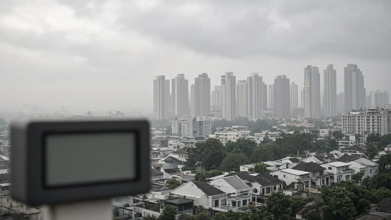 Hazy skyline over Lentor estate rooftops with NEA-style air quality sign blurred in foreground, overcast afternoon, no logos or readable text