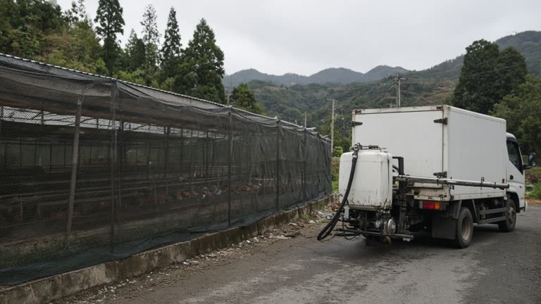 Taiwan poultry farm with protective netting and a disinfection truck on a rural road, documentary wire photo, slight underexposure, no logos, no identifiable faces
