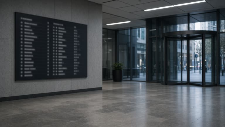 Empty modern office tower lobby in an Australian CBD with matte stone floors and a blurred tenant directory panel, cool fluorescent light, no logos or readable text
