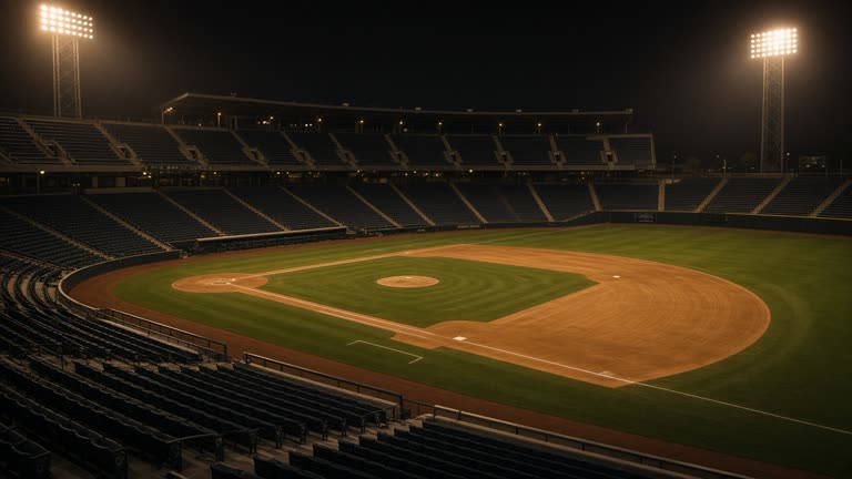 Hanshin Koshien Stadium stands with empty seats before an evening game, diamond infield freshly dragged, amber floodlights warming, no logos or readable text