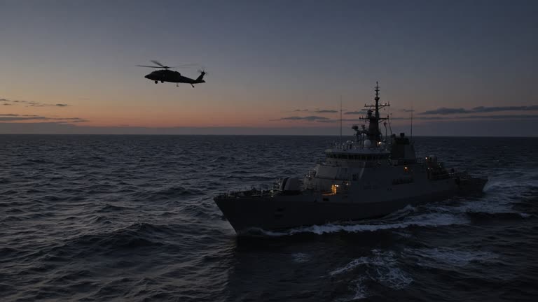 Coast Guard cutters and a search helicopter operate in choppy Atlantic waters off Nantucket at dusk