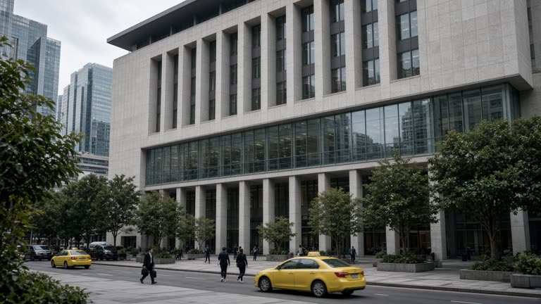 The Monetary Authority of Singapore building facade on a cloudy day, with office workers and taxis passing on the street below.